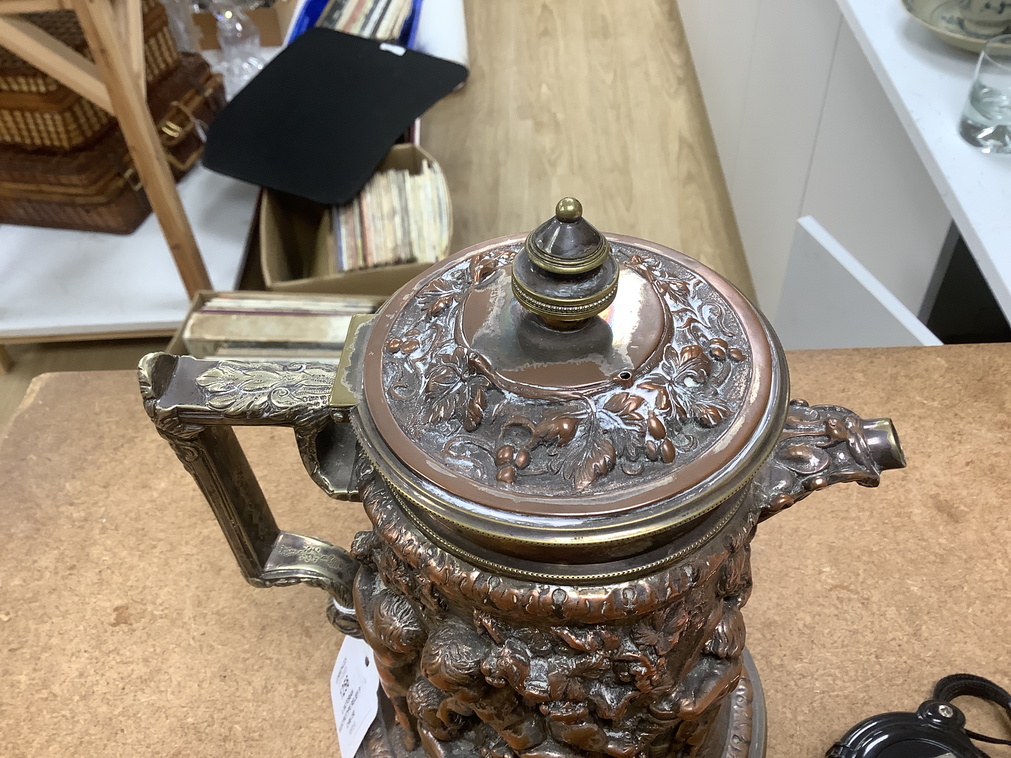 A Victorian electrotype relief putti jug with hinged cover. 24cm high